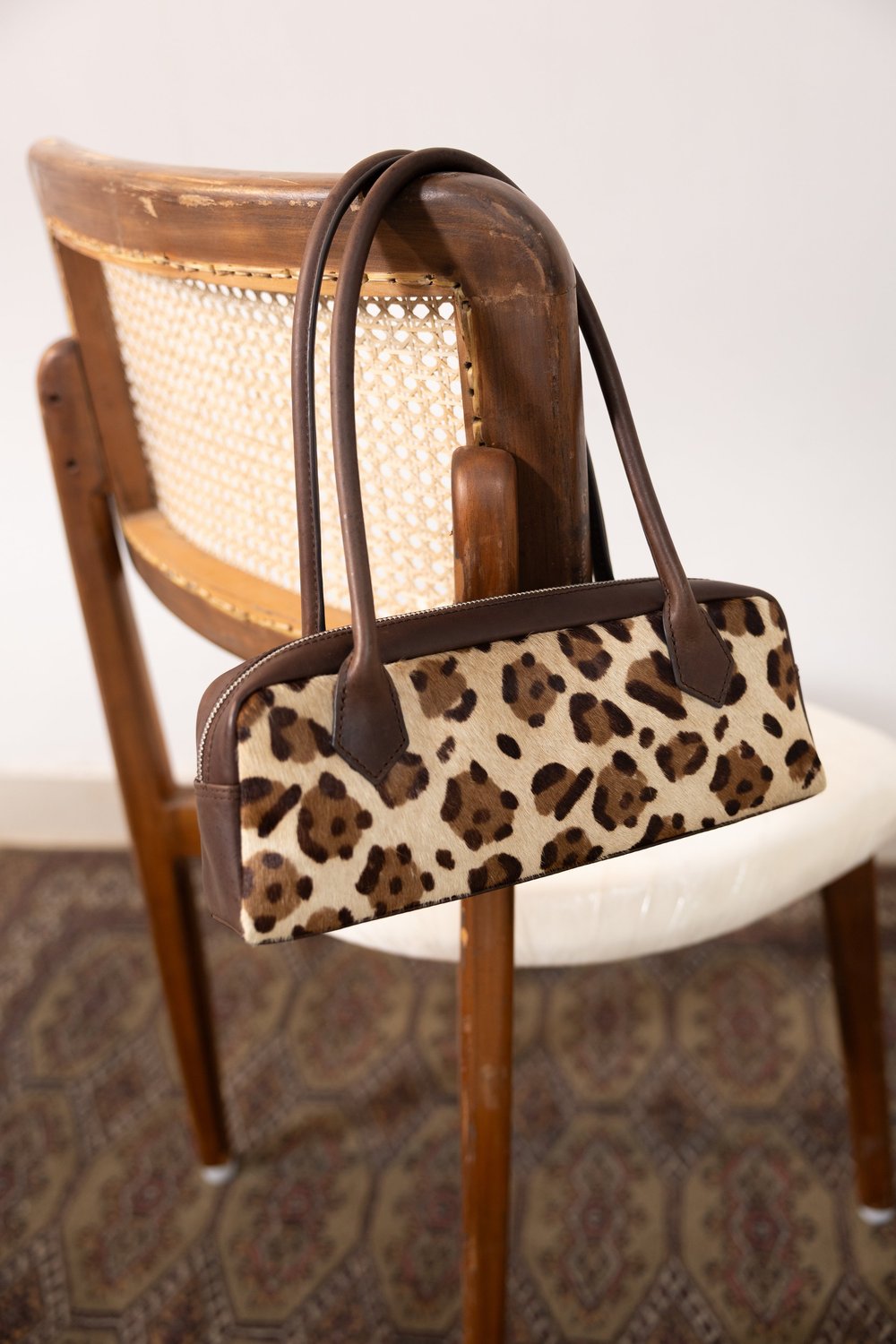 Leopard print leather handbag styled as a premium still life by Raja & Mitsu Fashions